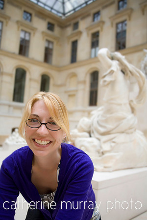 Young thirty-year-old woman leaning over in the statue room of the Louvre