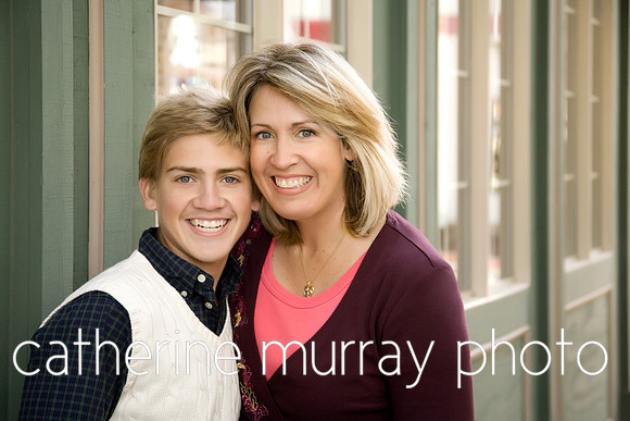 A mom and teenage son posing near a storefront